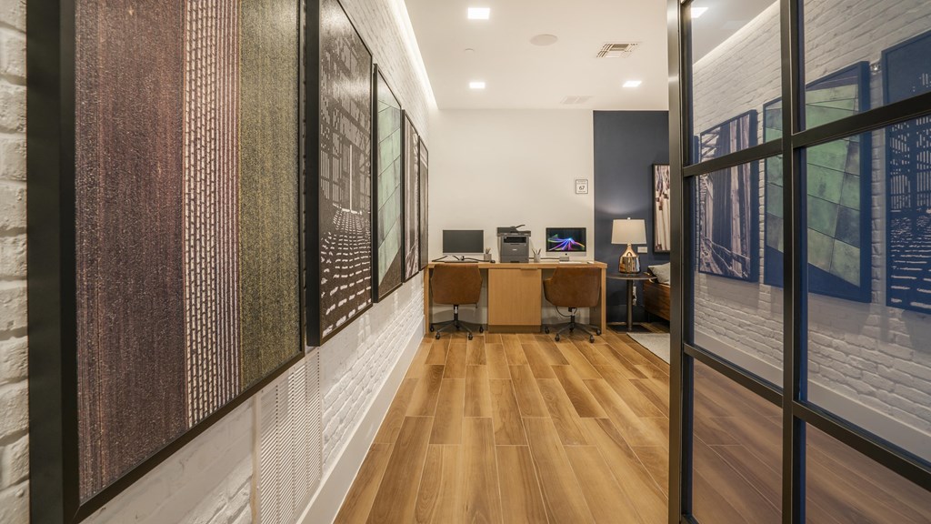 a long hallway with wood floors and a desk with a computer