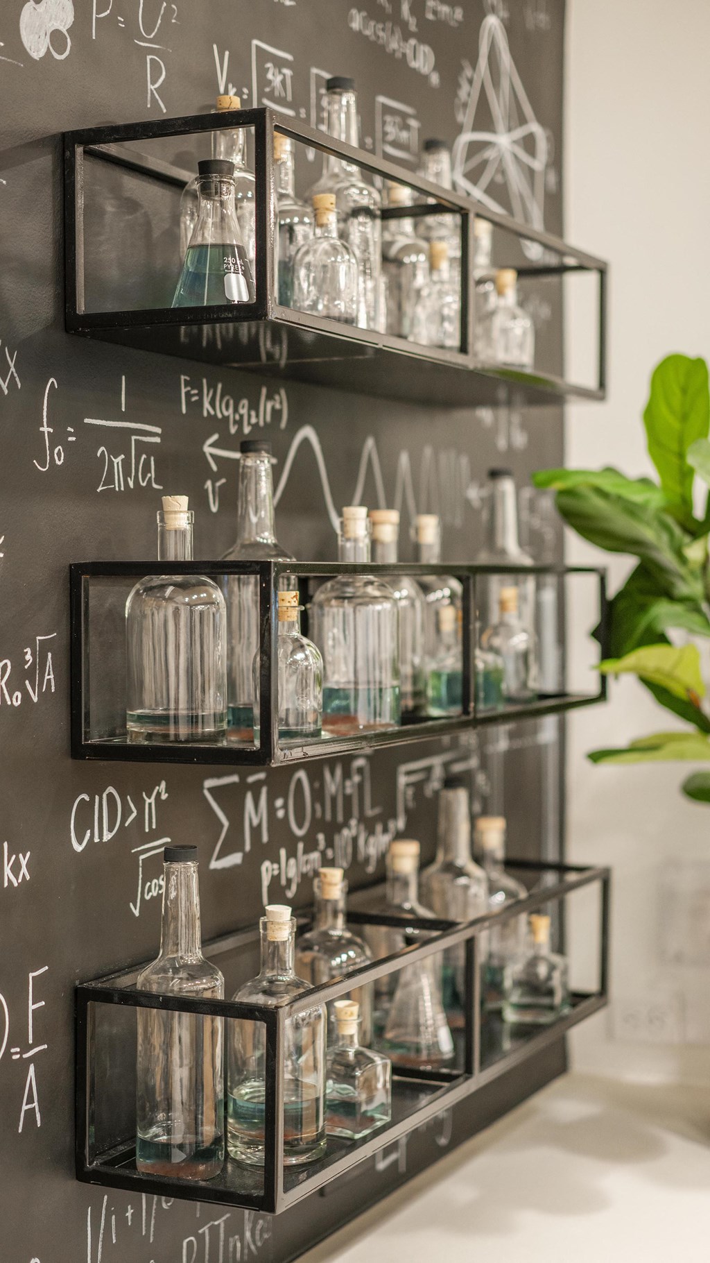 a chalkboard wall with bottles and glasses on it