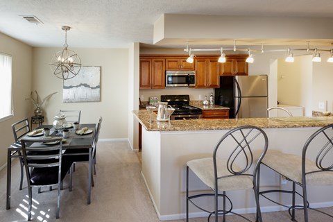 A kitchen with a dining table and chairs.