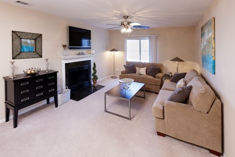 A living room with a fireplace, a couch, a coffee table, and a painting on the wall.