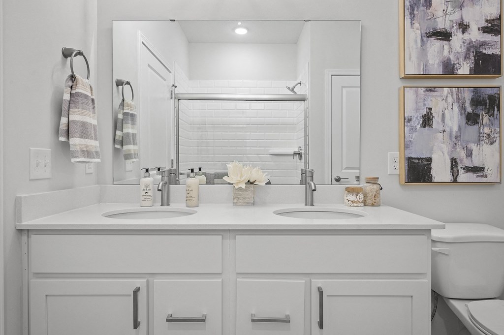 a white bathroom with two sinks and a mirror
