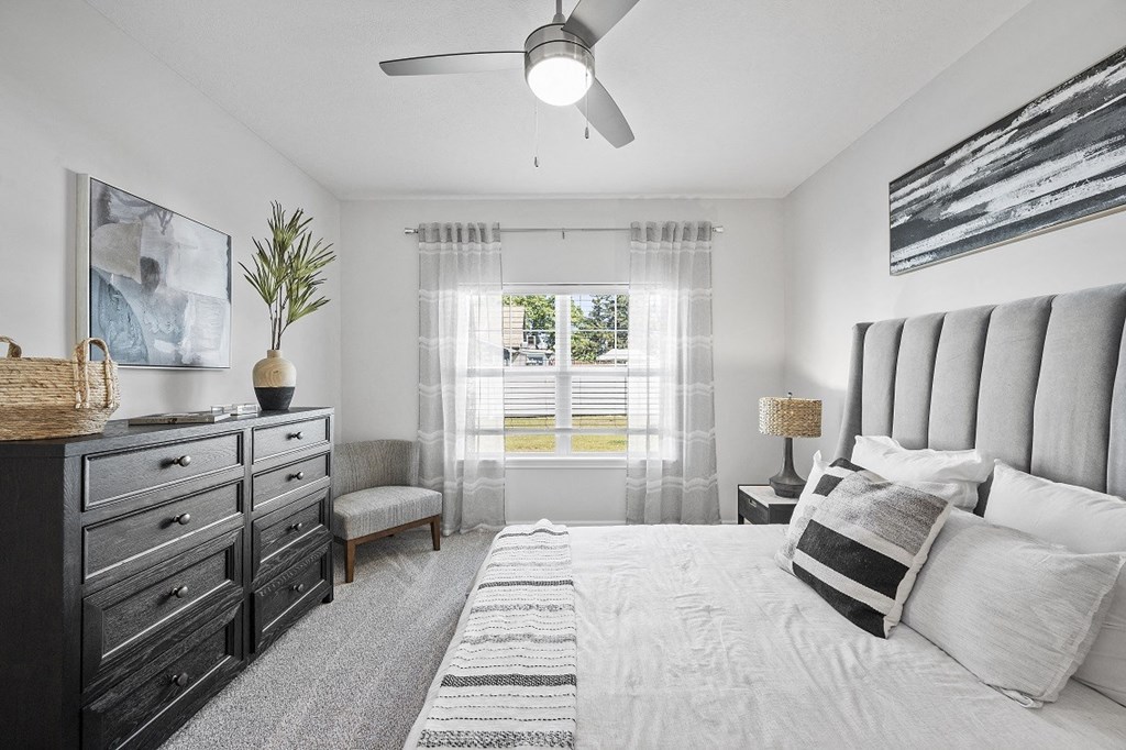 a bedroom with a large bed and a ceiling fan