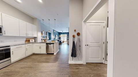 A kitchen with white cabinets and a wooden floor.