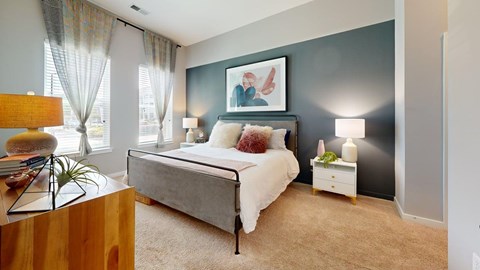 A bedroom with a bed, nightstand, and lamp.