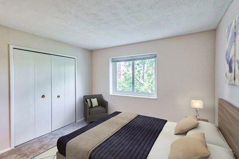 A bedroom with a bed, chair, and wardrobe.