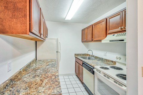 A kitchen with granite countertops and white appliances.