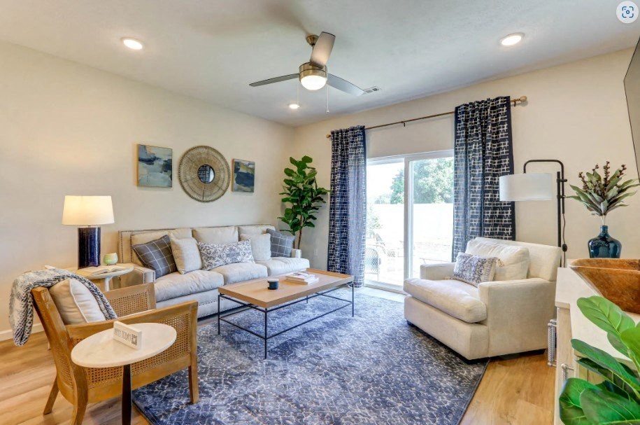 a living room with couches and chairs and a sliding glass door