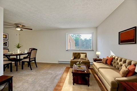 A living room with a brown couch and a dining table.