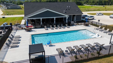 A pool with a black fence and a black and white striped poolside.