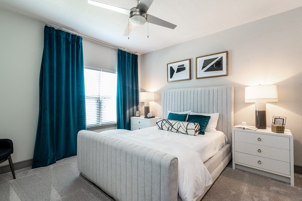 a bedroom with a white bed and blue curtains