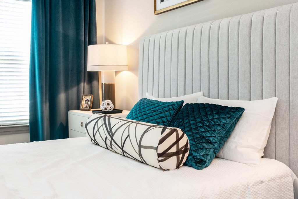 a bedroom with a white bed and blue pillows