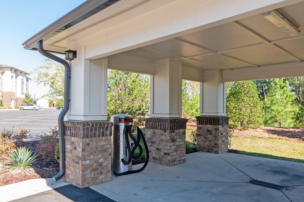a gas pump at a gas station in a parking lot
