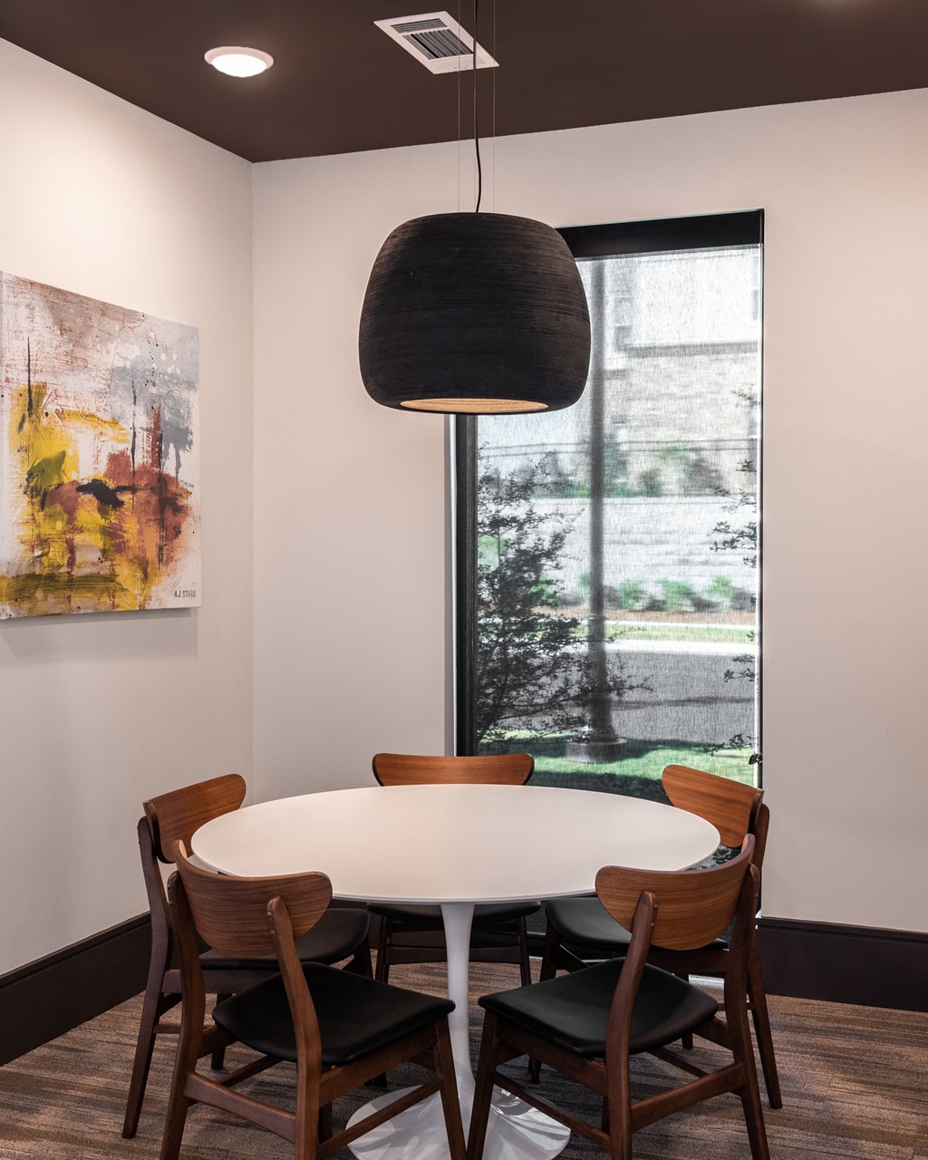 a dining room with a white table and chairs and a large window