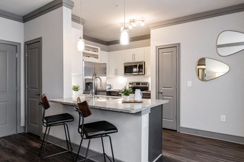 a kitchen with a marble counter top and two stools