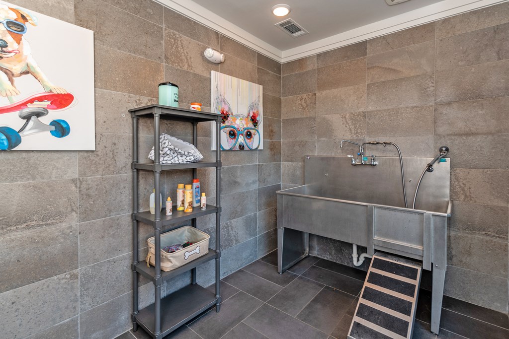 the bathroom has a large stainless steel tub and a sink
