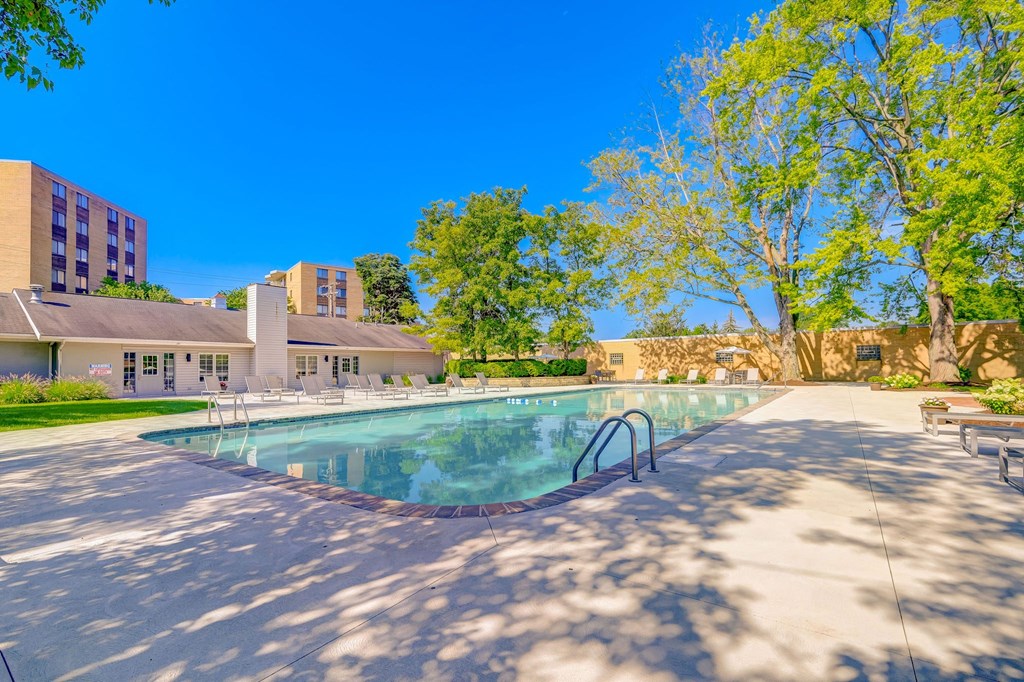 a swimming pool with trees and a building in the background