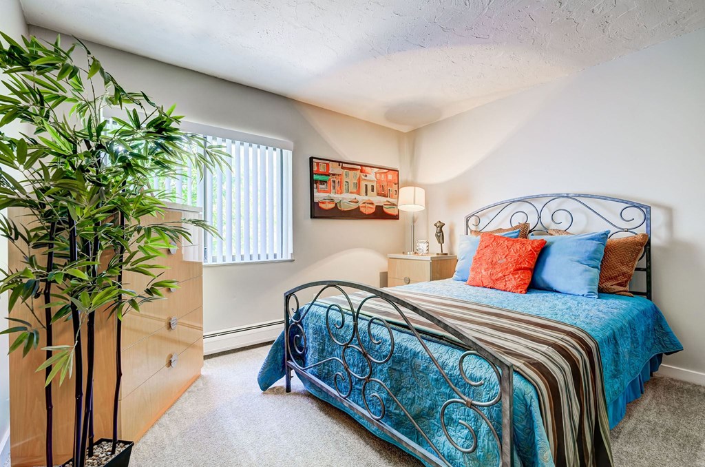 a bedroom with a bed and a potted plant