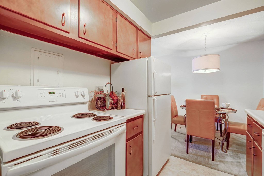 a kitchen with a stove and refrigerator and a dining room with a table