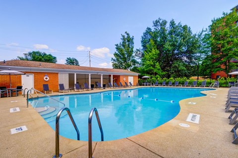 A large outdoor swimming pool with a building in the background.