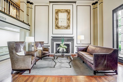 A living room with a fireplace and a painting above it.