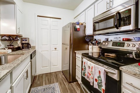 A kitchen with a black stove top oven and a black microwave above it.