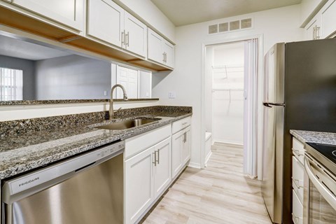 A kitchen with granite countertops and stainless steel appliances.