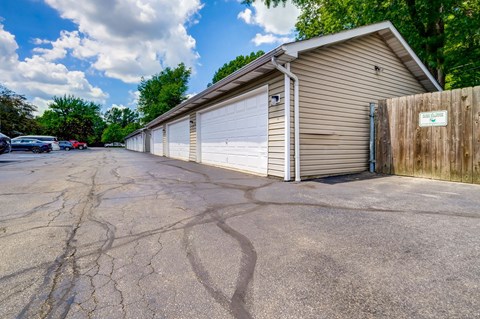 A parking lot with a building and a wooden fence.