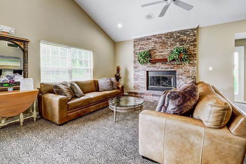 A living room with a couch, coffee table, and a fireplace.
