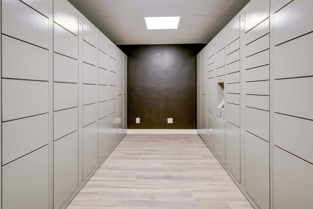 a long hallway with white lockers and a dark wall