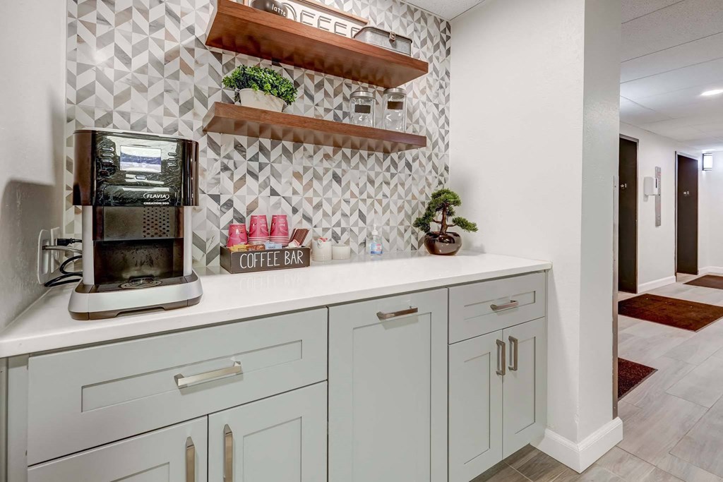 a white kitchen with a coffeemaker on the counter