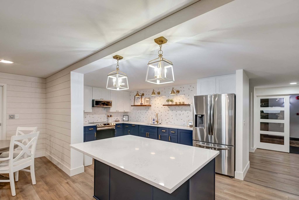 a kitchen with an island and a stainless steel refrigerator