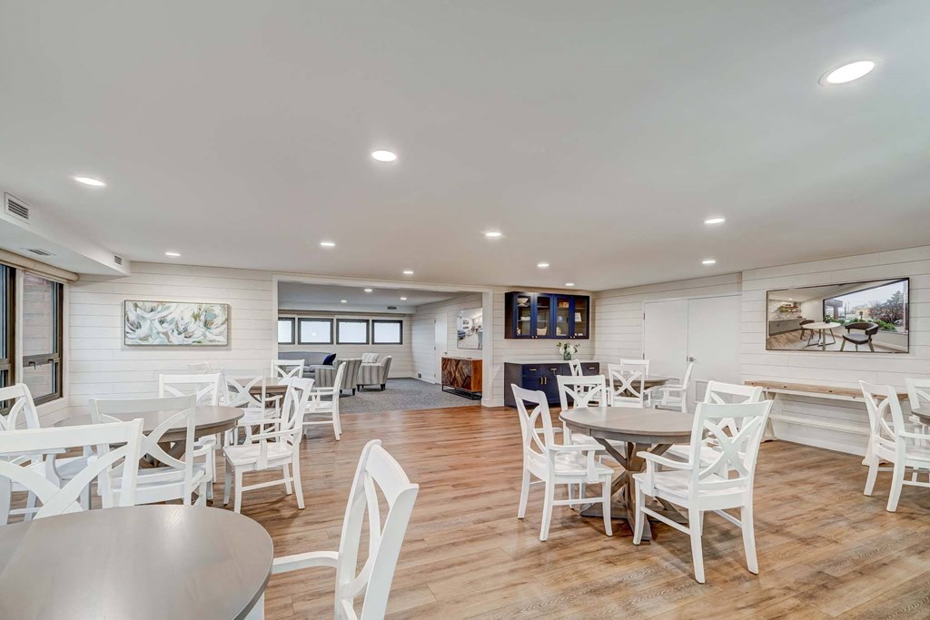 a dining room with tables and chairs and a kitchen