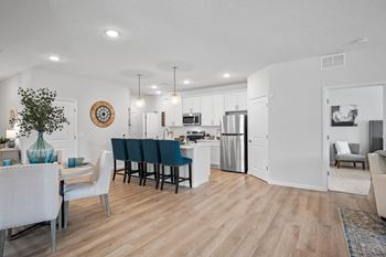 the living room and dining room of an open floor plan with a kitchen and dining