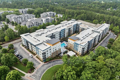 An aerial view of a large apartment complex surrounded by trees.