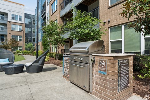 A trash can with a recycling bin on top is in front of a brick building.