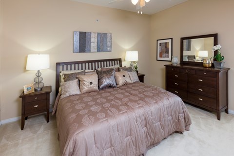 A bedroom with a large bed and a dresser.