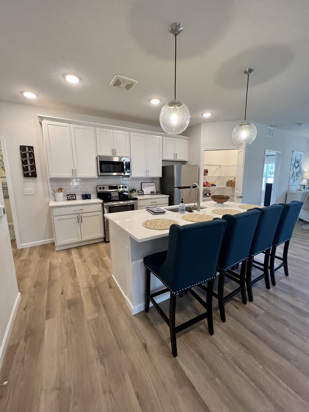 a view of a kitchen with a island and blue chairs
