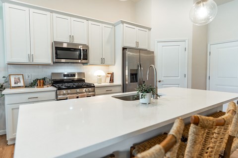 A kitchen with white cabinets and a white countertop.