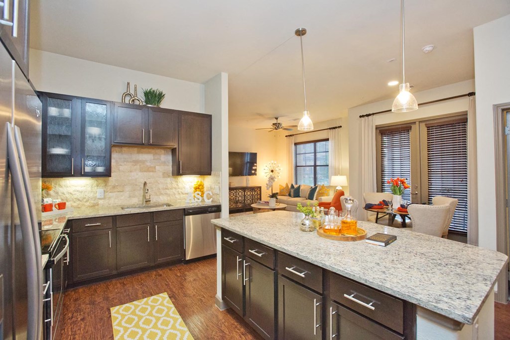 a kitchen and living room with a marble counter top