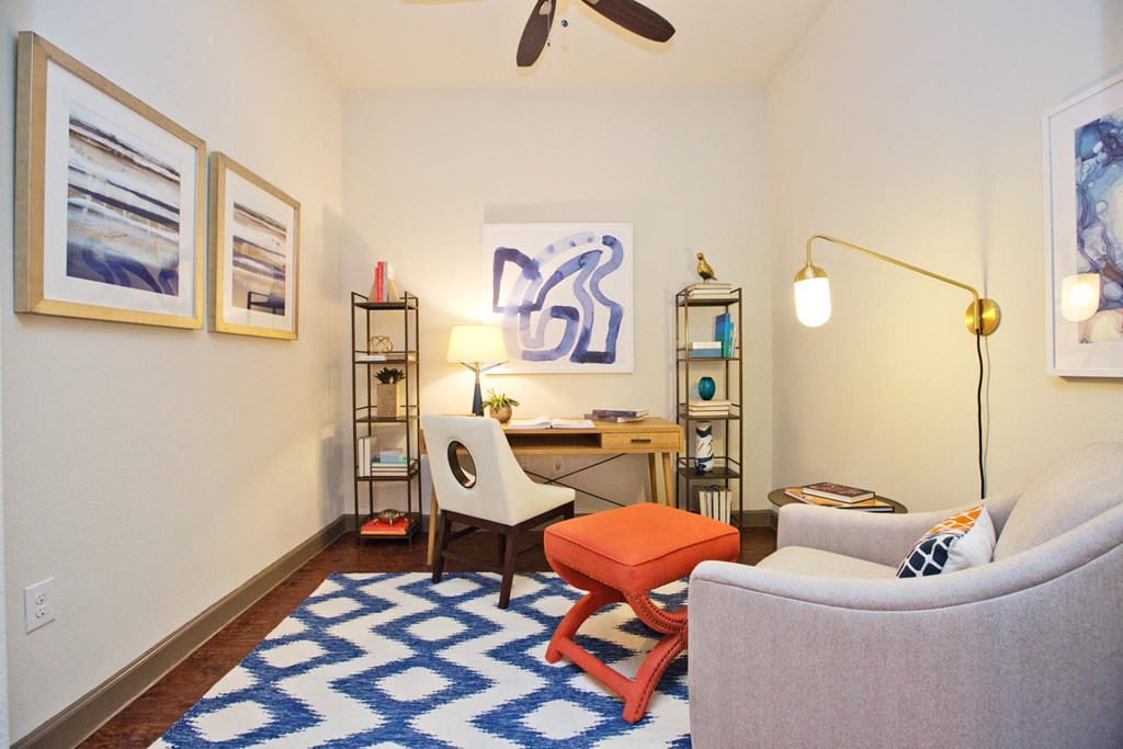 a living room with a couch and a chair and a desk