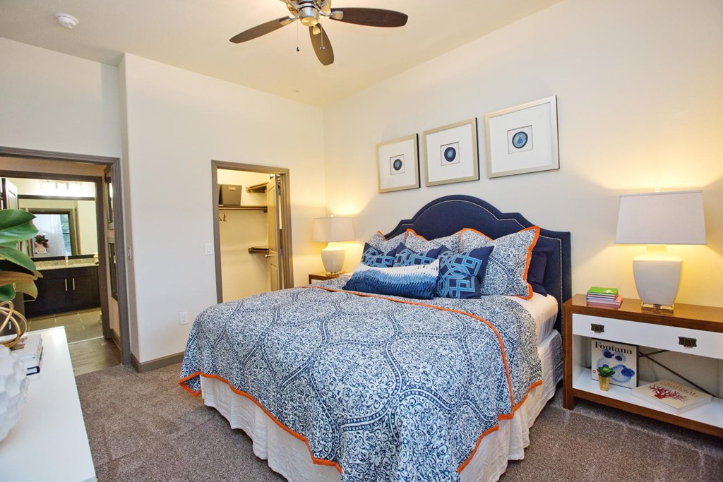a bedroom with a bed and a ceiling fan