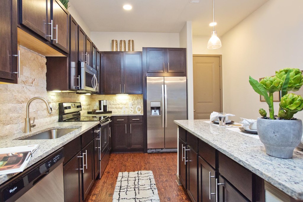 a large kitchen with stainless steel appliances and marble counter tops