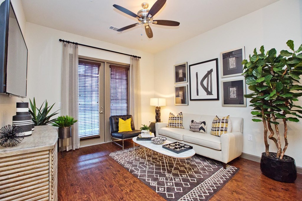 a living room with a white couch and a ceiling fan