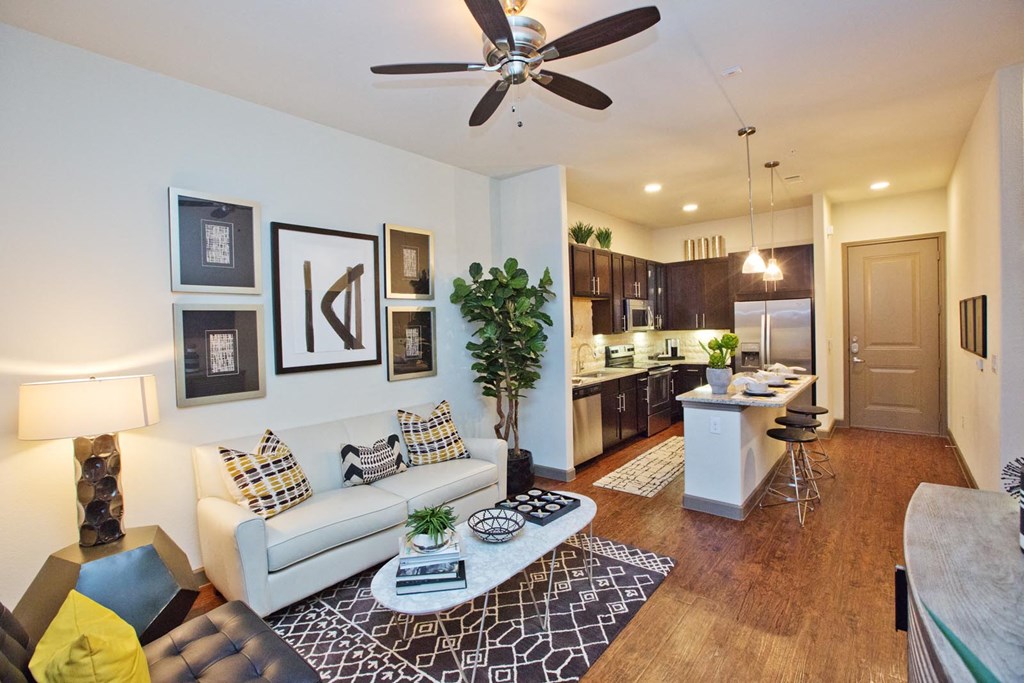 a living room and kitchen with a ceiling fan