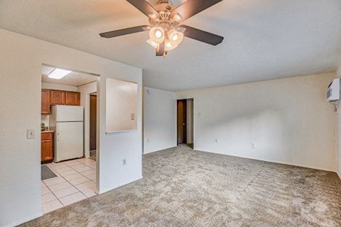 A spacious room with a ceiling fan and carpeted floor.