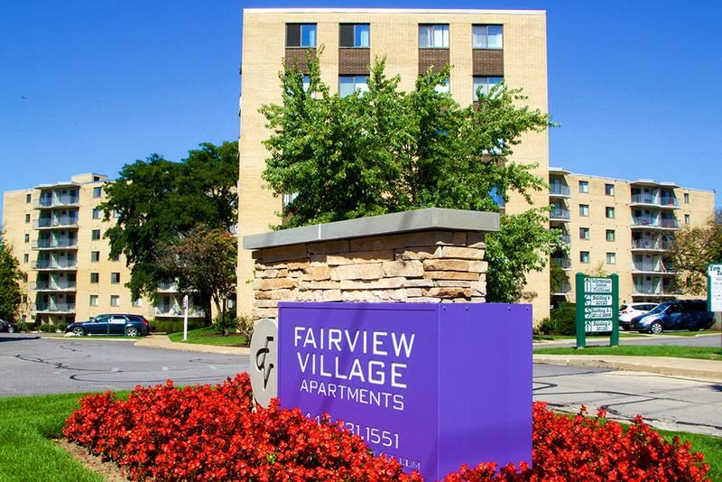 a sign for fairview village apartments in front of a building