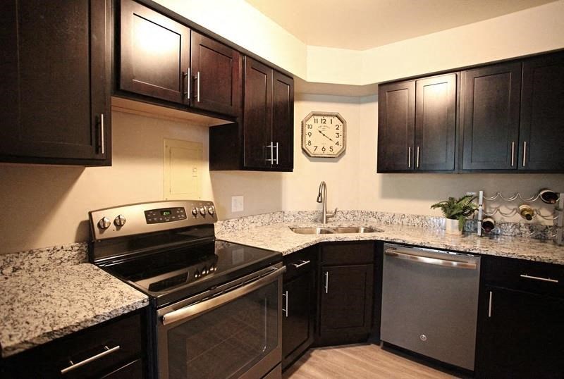 A kitchen with black cabinets and granite countertops.