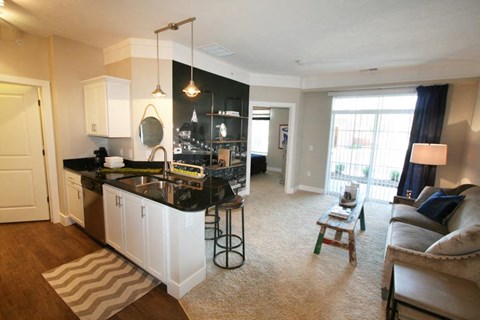 A modern kitchen with white cabinets and a black countertop.