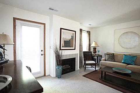 A living room with a fireplace and a painting on the wall.