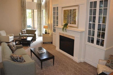 A living room with a fireplace and a painting on the wall.